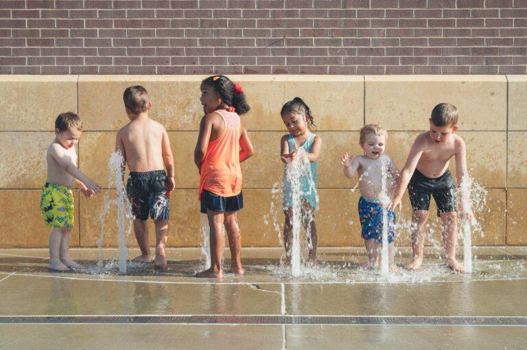 Children playing in water fountain