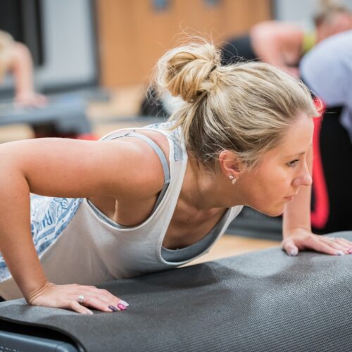 woman doing a press up in a circuit training class