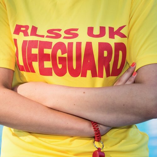 Lifeguard stood next to swimming pool