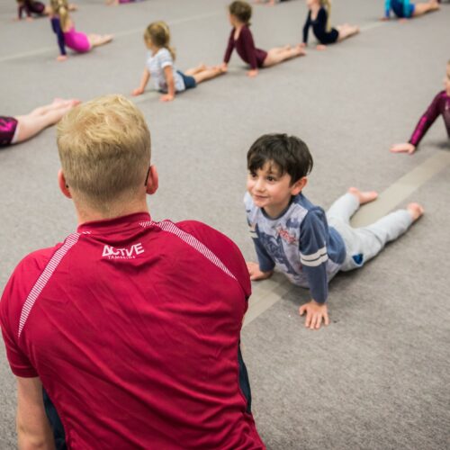 children listening to coach at mini tumblers gymnastics lessons