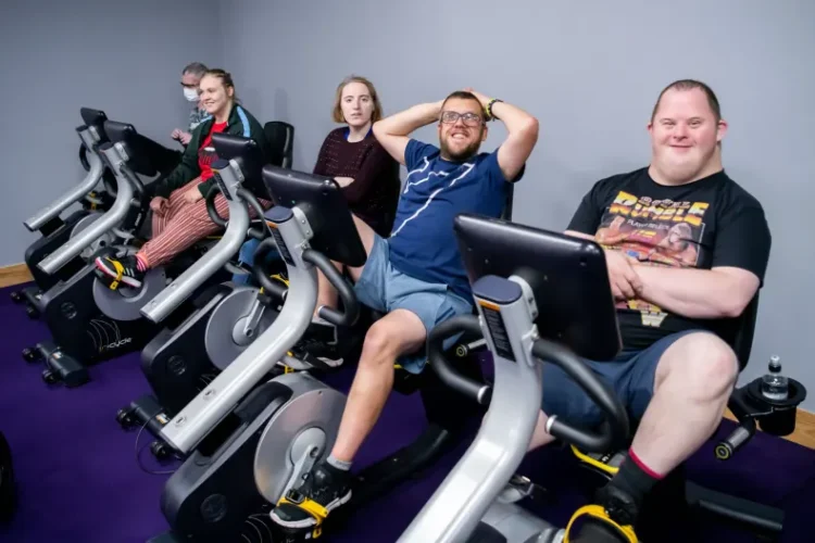 group of people on accessible exercise bikes smiling