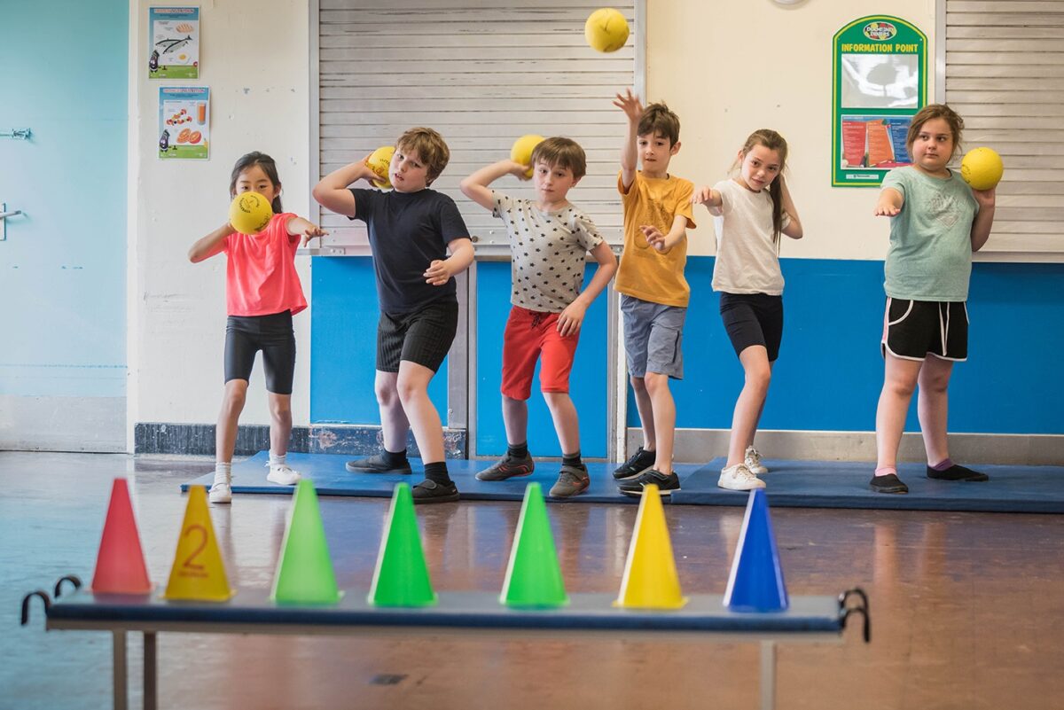 children playing with balls and cones