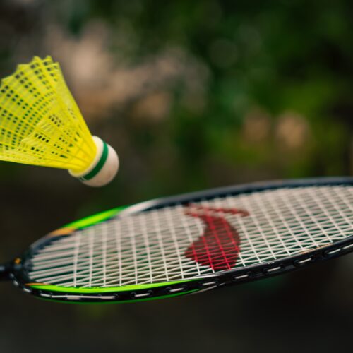 A badminton shuttlecock bouncing off a badminton racket