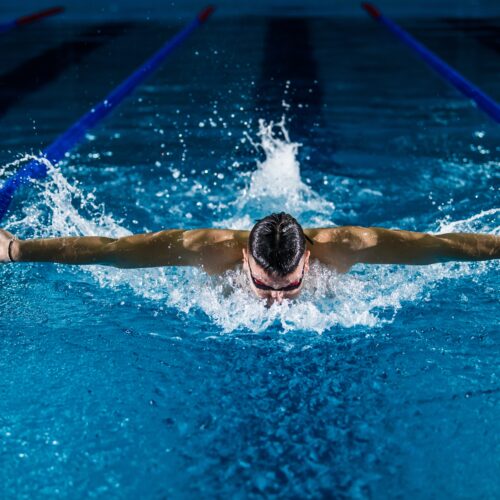 man doing the butterfly stroke in the pool