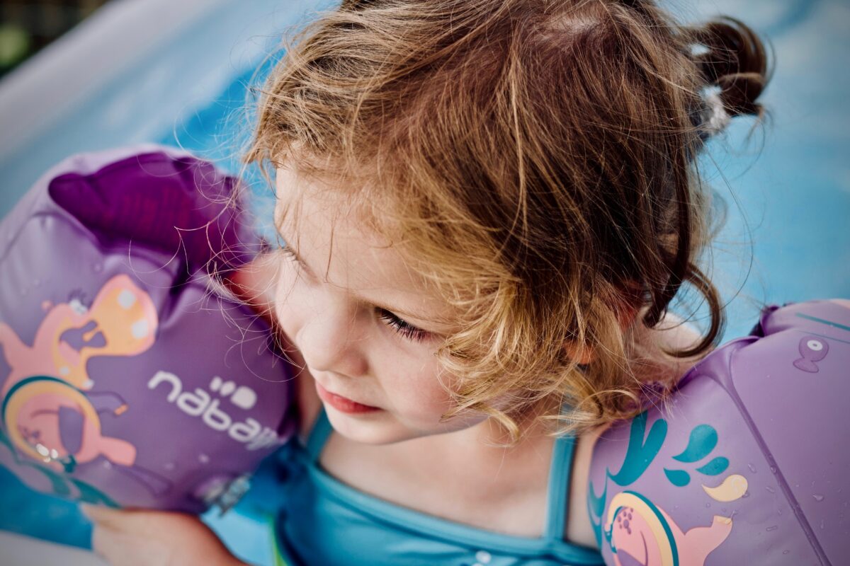 toddler in arm bands in the pool