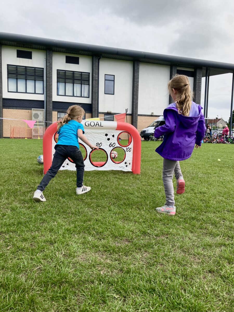 two young girls playing with a mini goal with targets