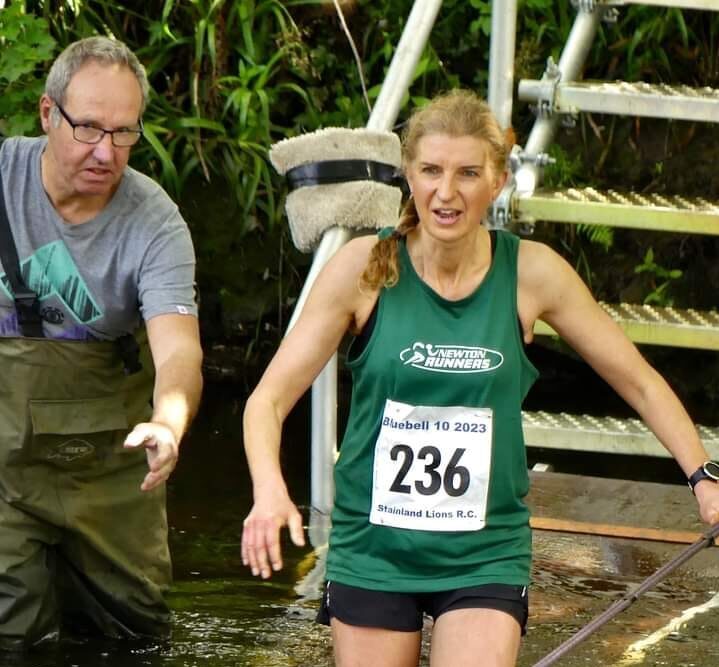 Jane wading through water at a running event
