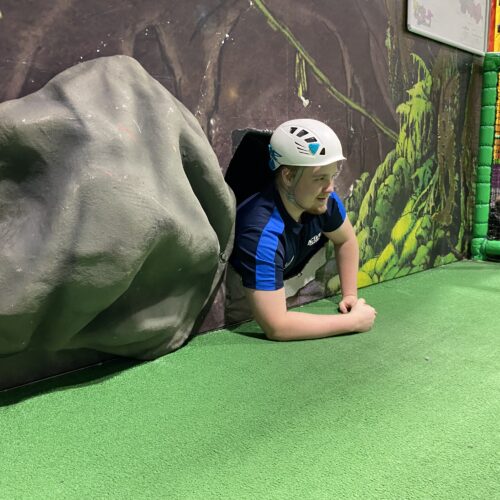 man exiting a cave as part of the caving experience at Active Medlock