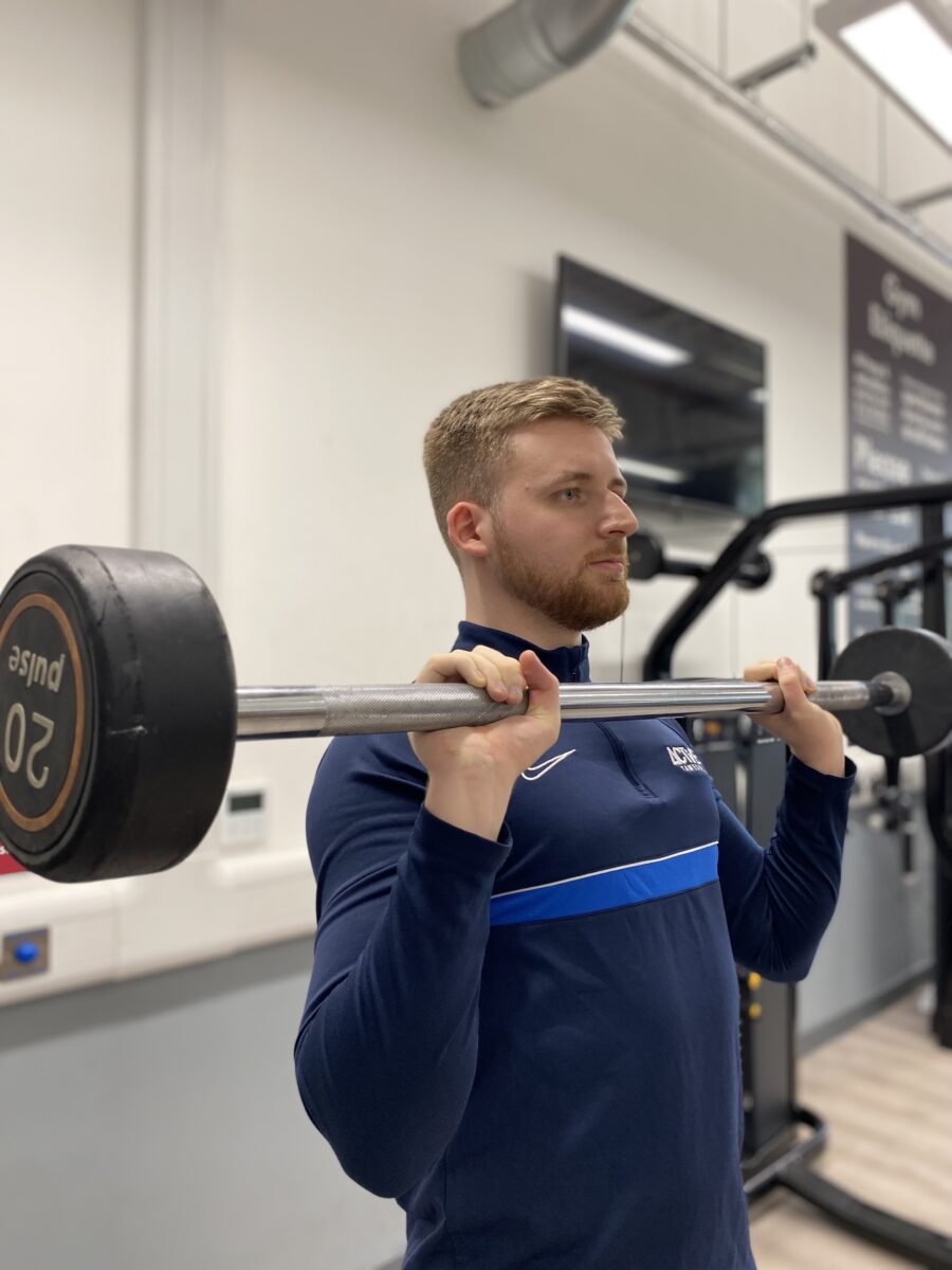 man with bar weight at chest